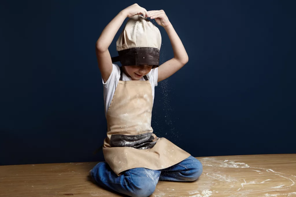 Enfant jouant avec de la farine.
