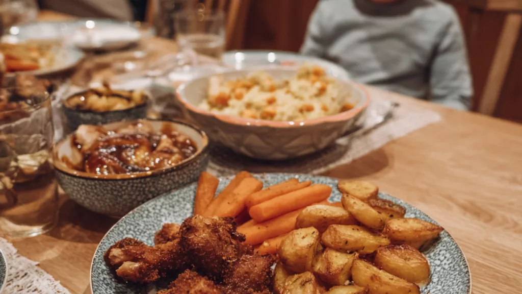 Repas de Noël servi sur une table familiale, avec des plats simples et une atmosphère conviviale