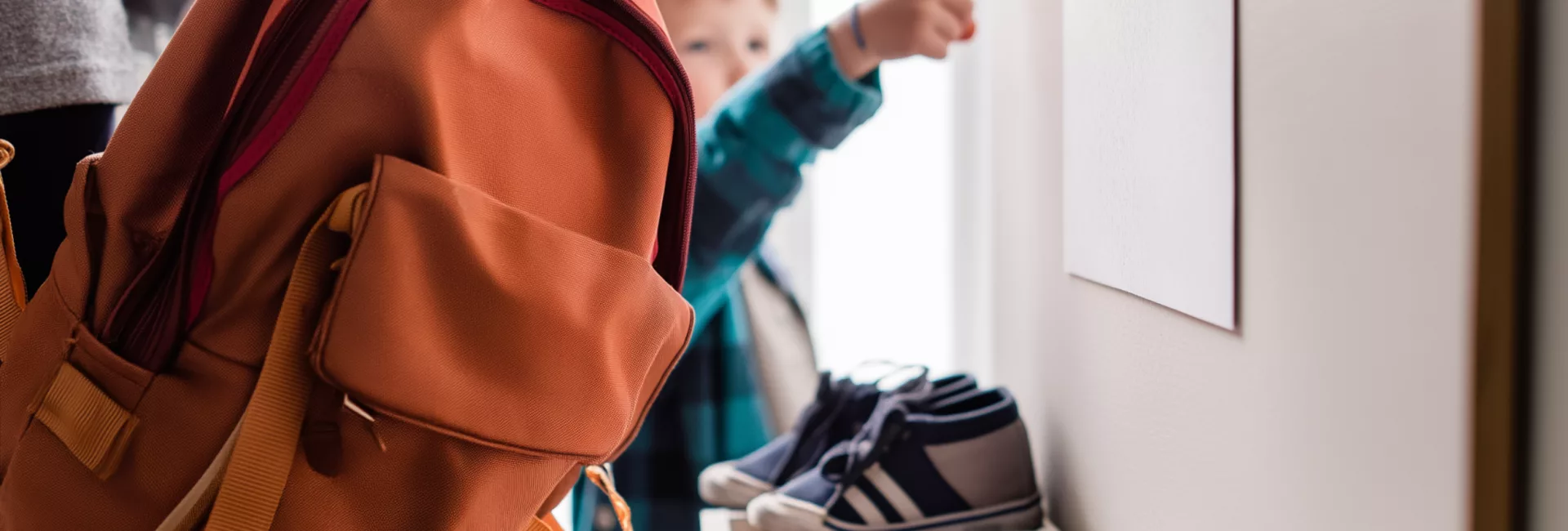 Parent et enfant observant une enveloppe à la maison, évoquant l’impact des délais MDPH sur la scolarité.