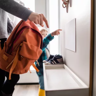 Parent et enfant observant une enveloppe à la maison, évoquant l’impact des délais MDPH sur la scolarité.