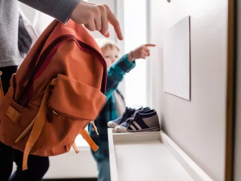 Parent et enfant observant une enveloppe à la maison, évoquant l’impact des délais MDPH sur la scolarité.