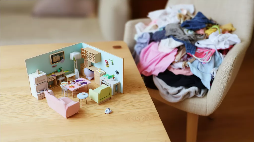 Désordre domestique : vêtements entassés sur une chaise à côté d'une maison miniature