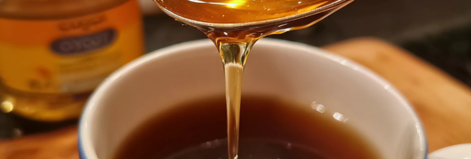 Cuillère de miel cru ou sirop d'agave coulant dans une tasse de café — remplacer le sucre par du miel dans son café