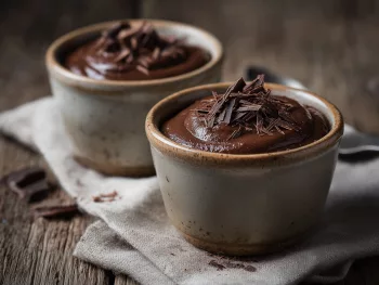 Crème au chocolat facile de Michalak servie dans deux ramequins en céramique artisanale sur une table en bois rustique