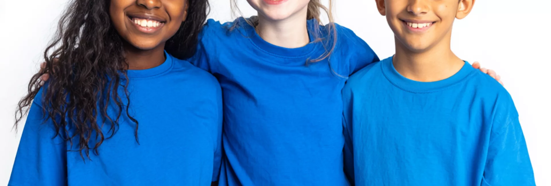 2 Avril Trois enfants souriants portant des t-shirts bleus pour la Journée mondiale de sensibilisation à l'autisme