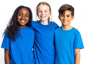 2 Avril Trois enfants souriants portant des t-shirts bleus pour la Journée mondiale de sensibilisation à l'autisme
