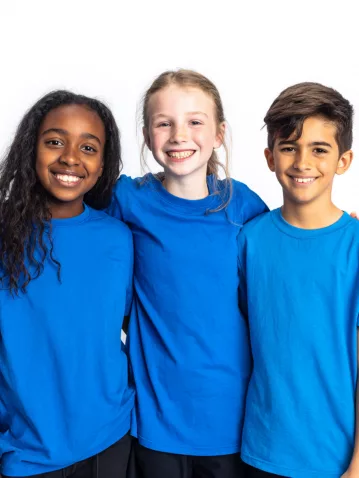 2 Avril Trois enfants souriants portant des t-shirts bleus pour la Journée mondiale de sensibilisation à l'autisme