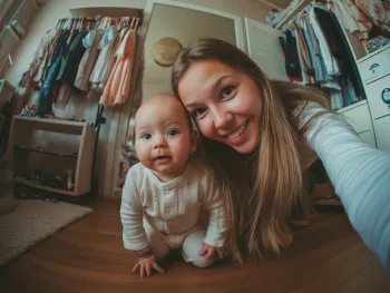 Assistante maternelle souriante prenant un selfie avec un bébé, à son domicile
