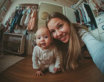 Assistante maternelle souriante prenant un selfie avec un bébé, à son domicile