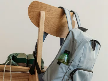 Rentrée scolaire 2026 Cartable gris accroché au dossier d'une chaise en bois, baskets posées sur l'assise, en fin de journée d'école